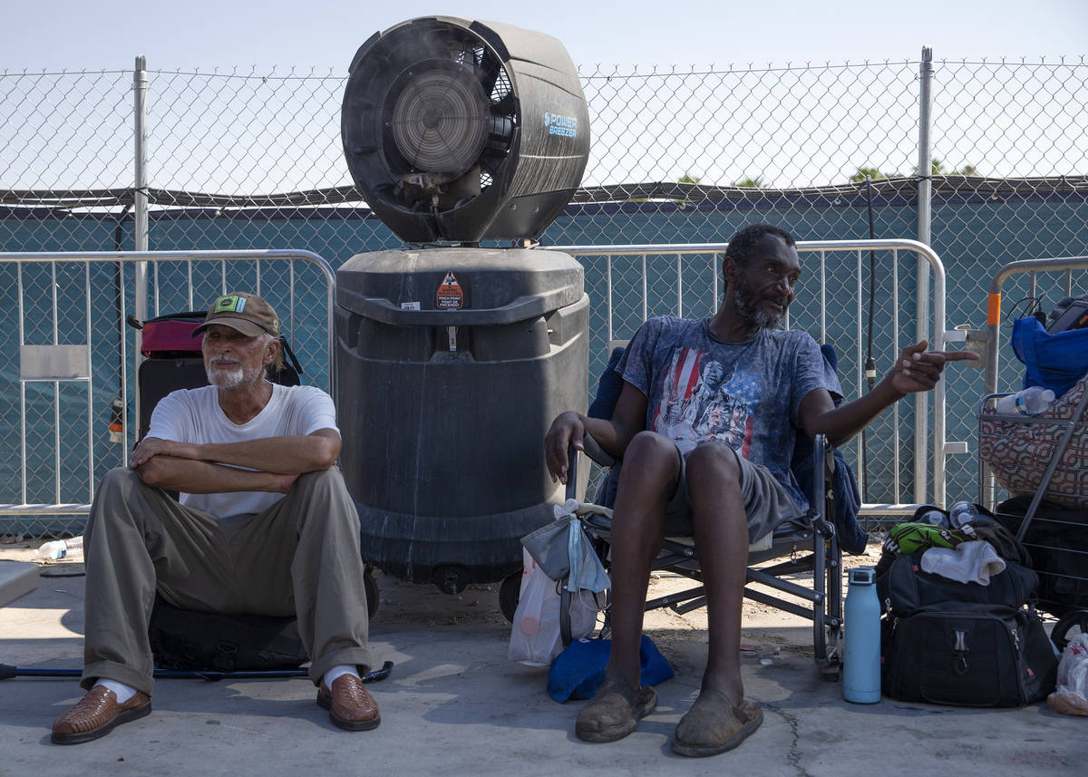 Jordan Patrick Andrews, left, and Daryl Cullins attempt to stay cool at Courtyard Homeless Reso ...