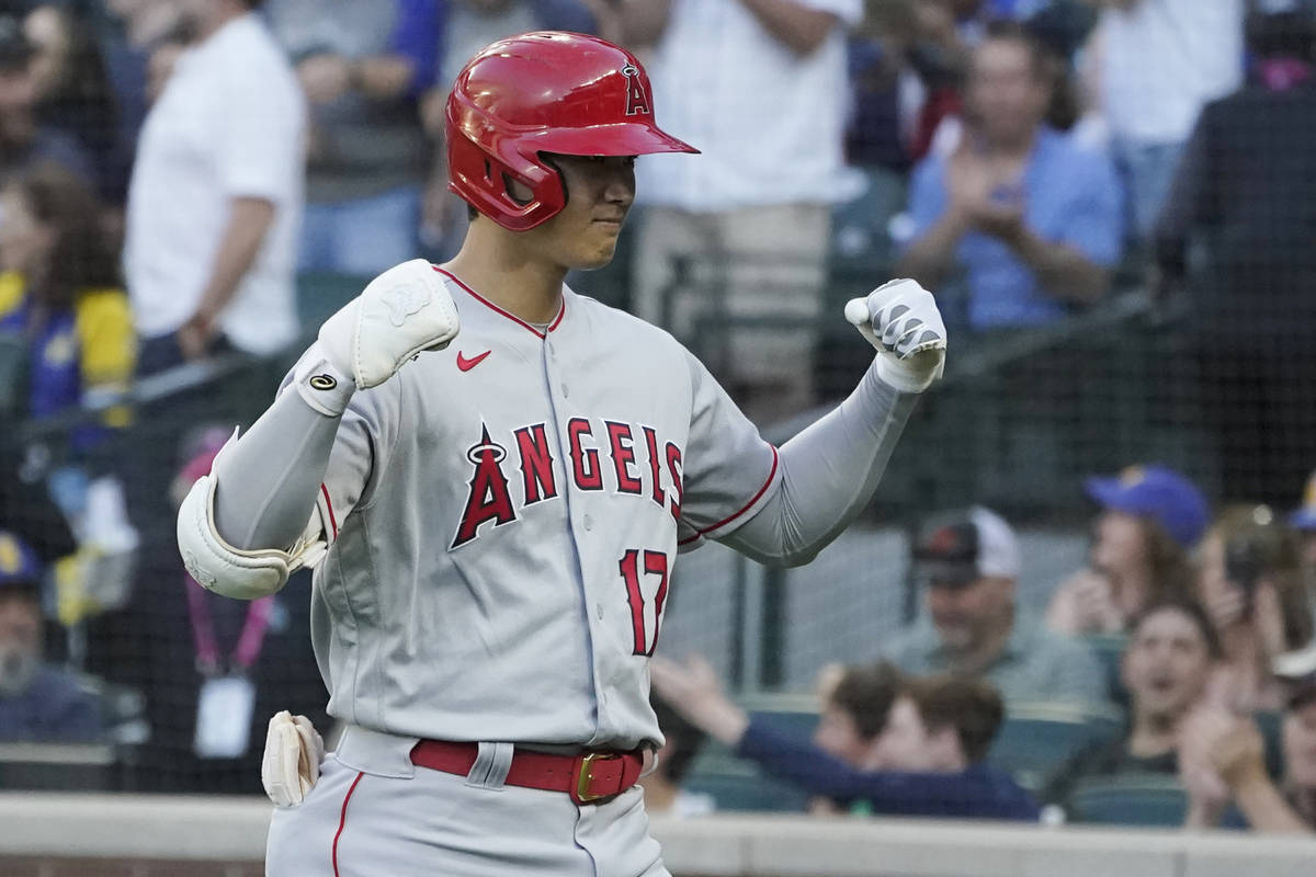 Los Angeles Angels' Shohei Ohtani flexes his arms after crossing the plate after he hit a solo ...