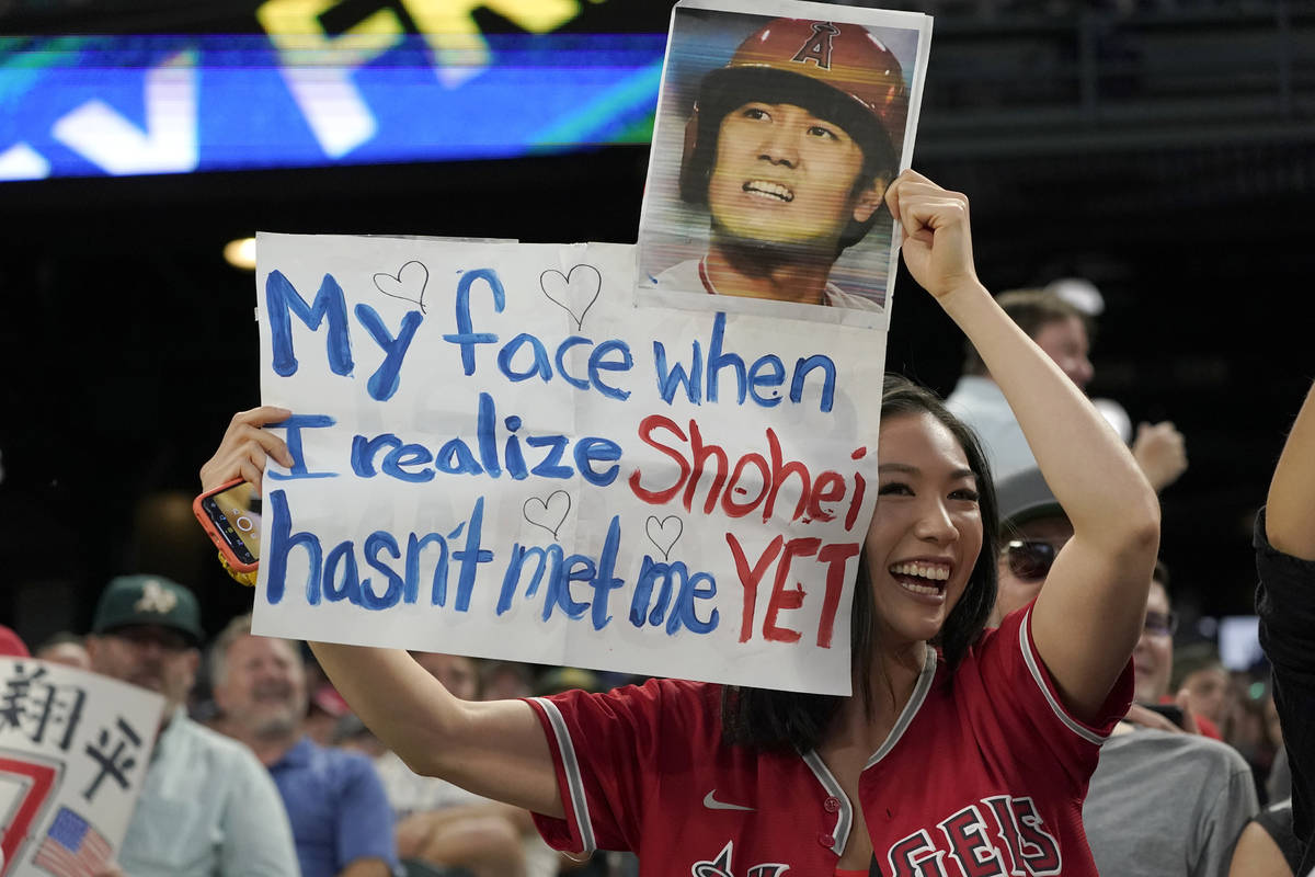 A fan holds a sign for Los Angeles Angels designated hitter Shohei Ohtani during the Angels' ba ...