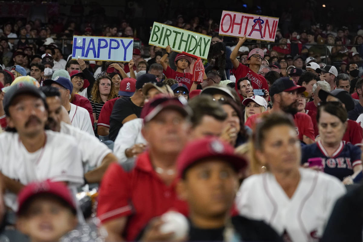 Fans hold up a sign for Los Angeles Angels designated hitter Shohei Ohtani's (17) birthday duri ...