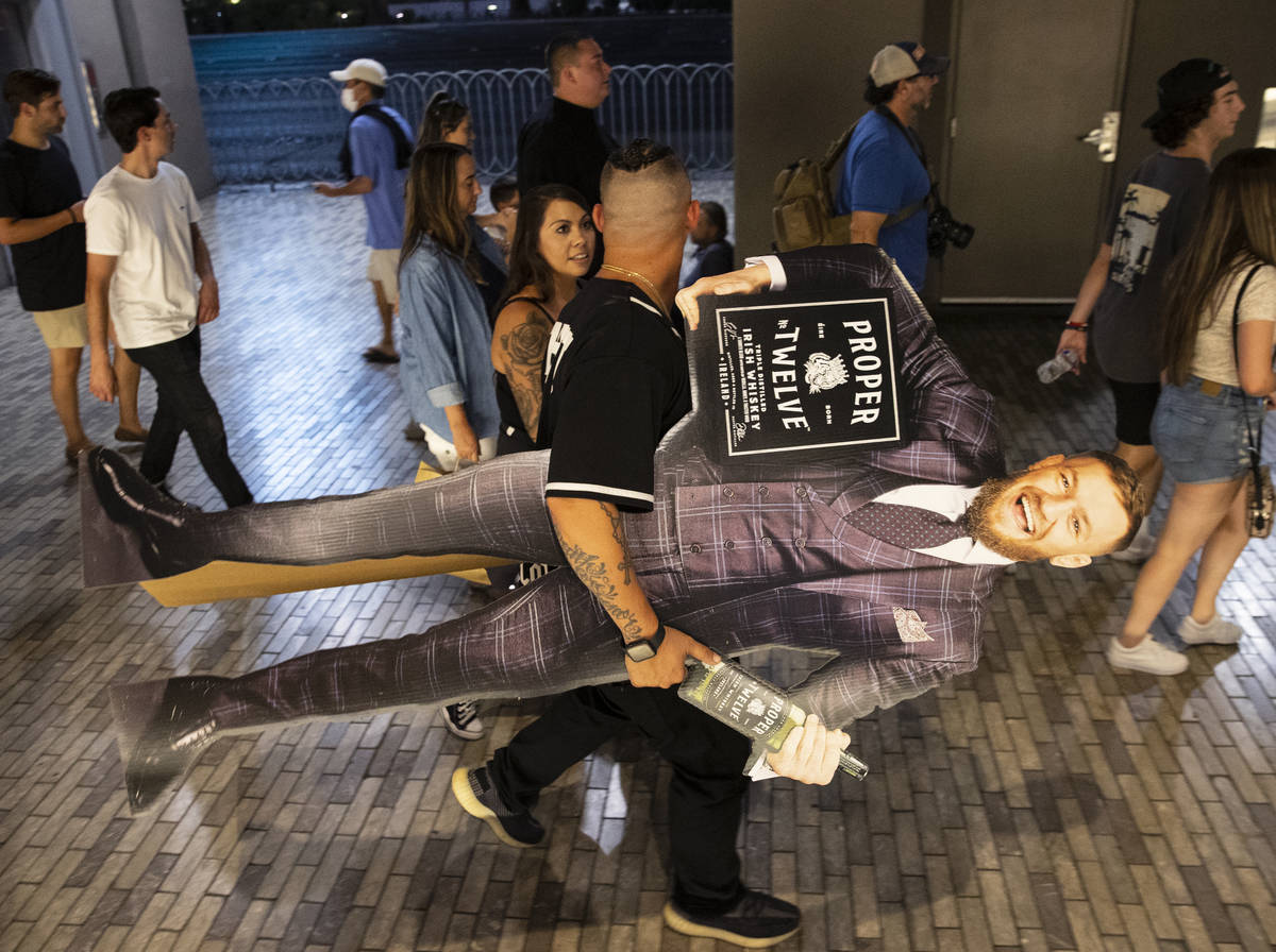 Roger Muntain of San Bernardino, Calif., a Conor McGregorÕs fan, carries McGregorÕs l ...