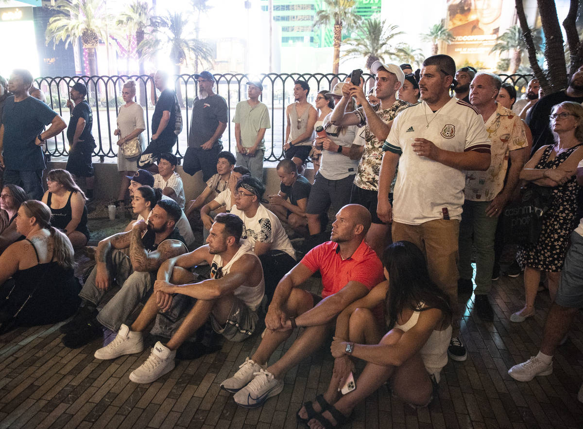 People gather to watch a televised UFC fight between Dustin Poirier and Conor McGregor outside ...