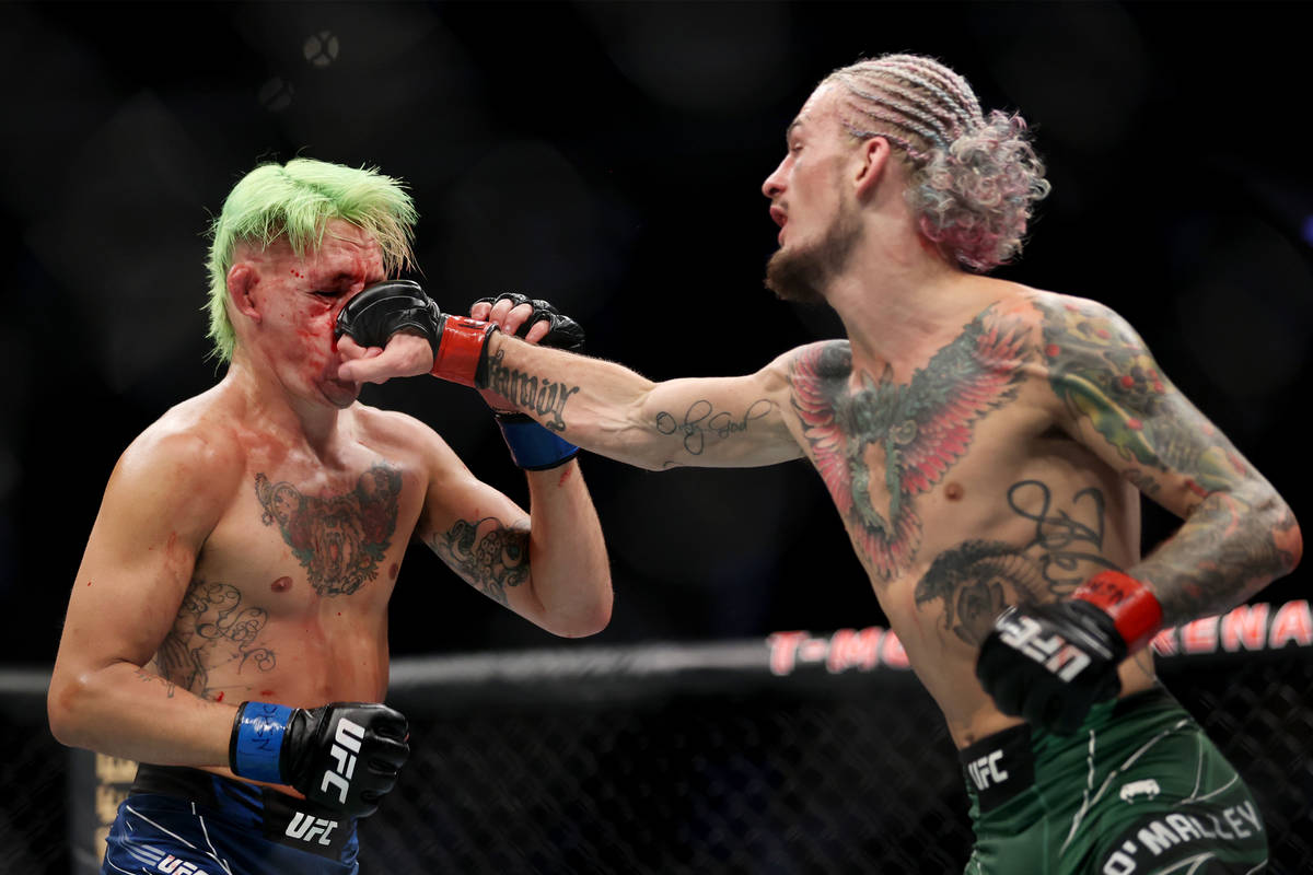 Sean O’Malley, right, connects a punch against Kris Moutinho in the third round of a ban ...