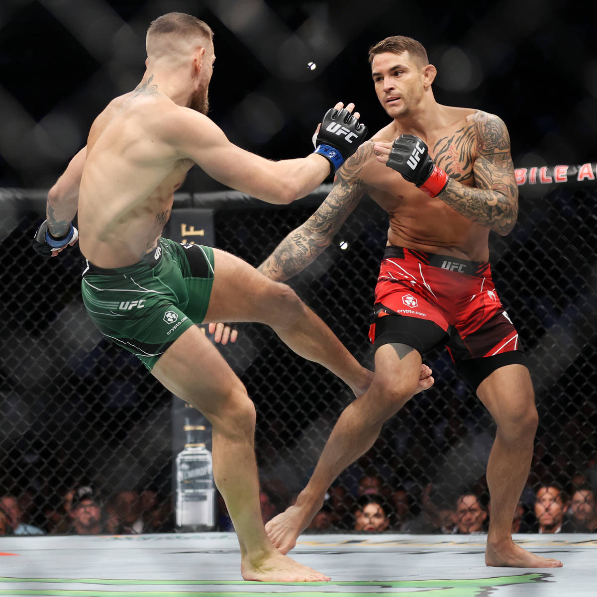 Conor McGregor, left, and Dustin Poirier, battles in the first round of a lightweight bout agai ...