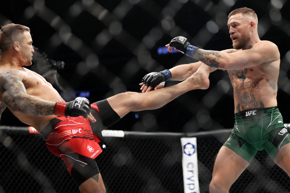Dustin Poirier, left, throws a kick against Conor McGregor in the first round of a lightweight ...