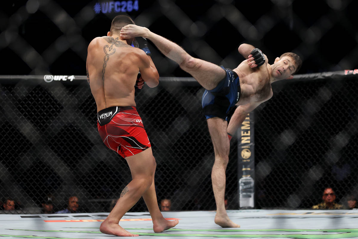Ilia Topuria, left, defends a kick against Ryan Hall in the first round of a featherweight bout ...