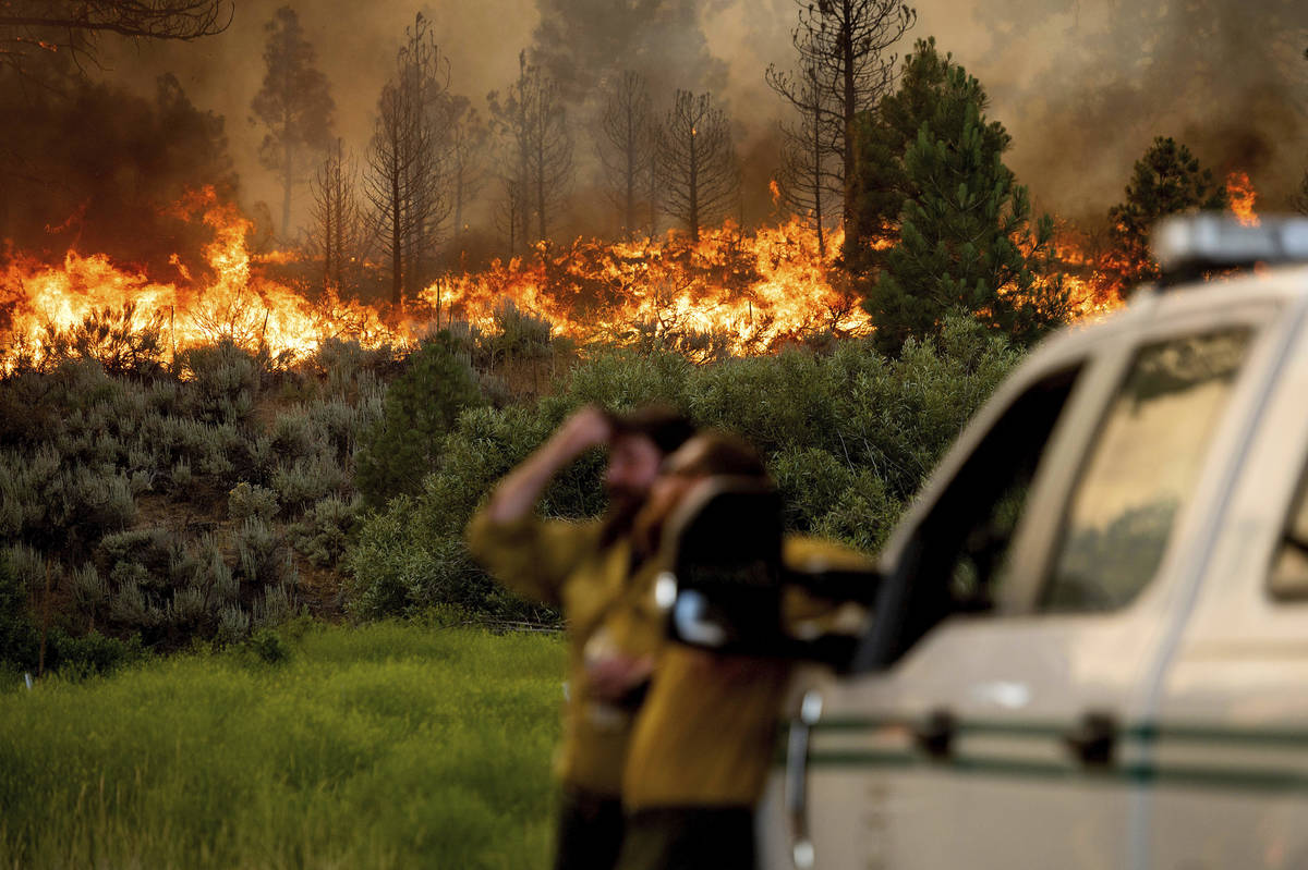 U.S. Forest Service firefighters Chris Voelker, left, and Kyle Jacobson monitor the Sugar Fire, ...