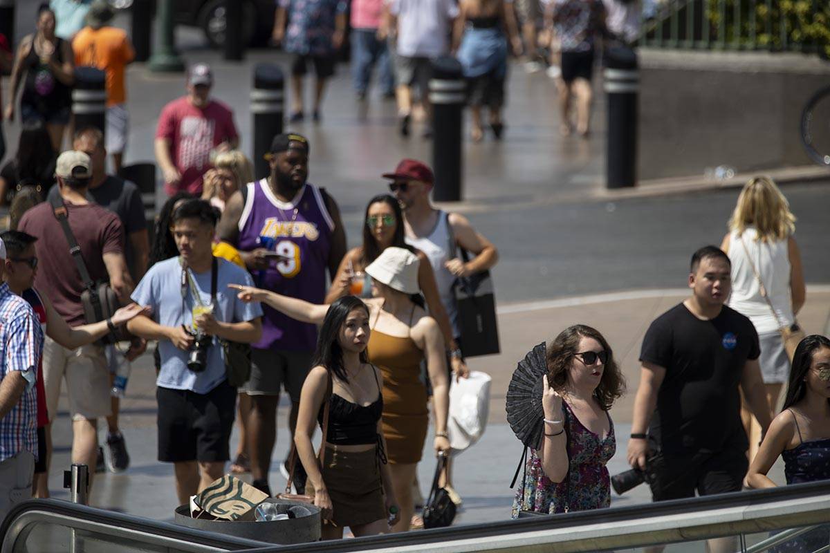 People walk on the Strip near Planet Hollywood hotel-casino in Las Vegas, Saturday, July 10, 20 ...