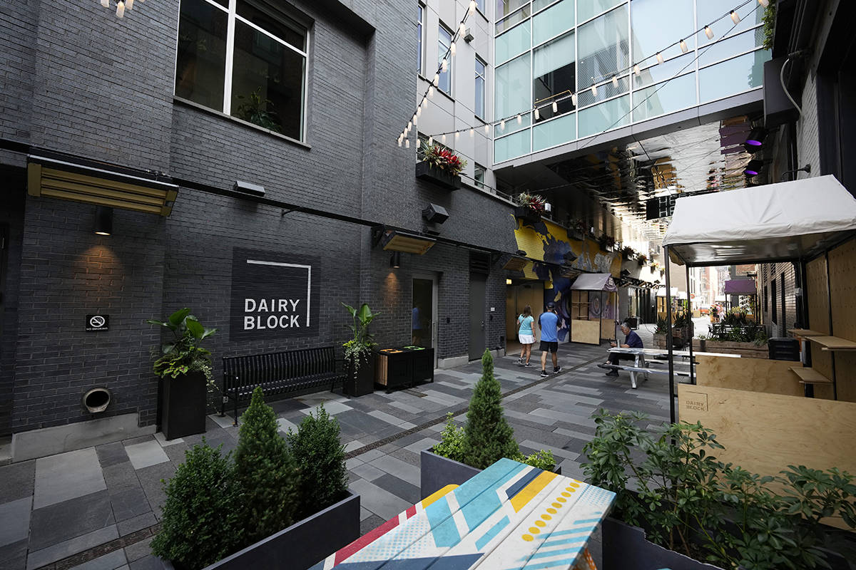 Pedestrians move through the alleyway in the Dairy Block and past the outside of the Maven Hote ...