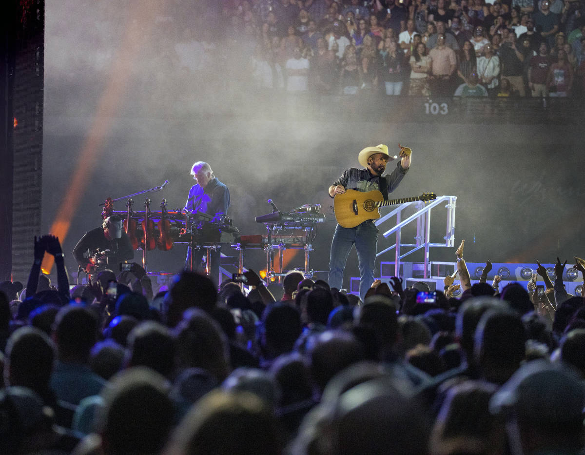 Garth Brooks signals the fans as he performs before the crowd at Allegiant Stadium on Friday, J ...