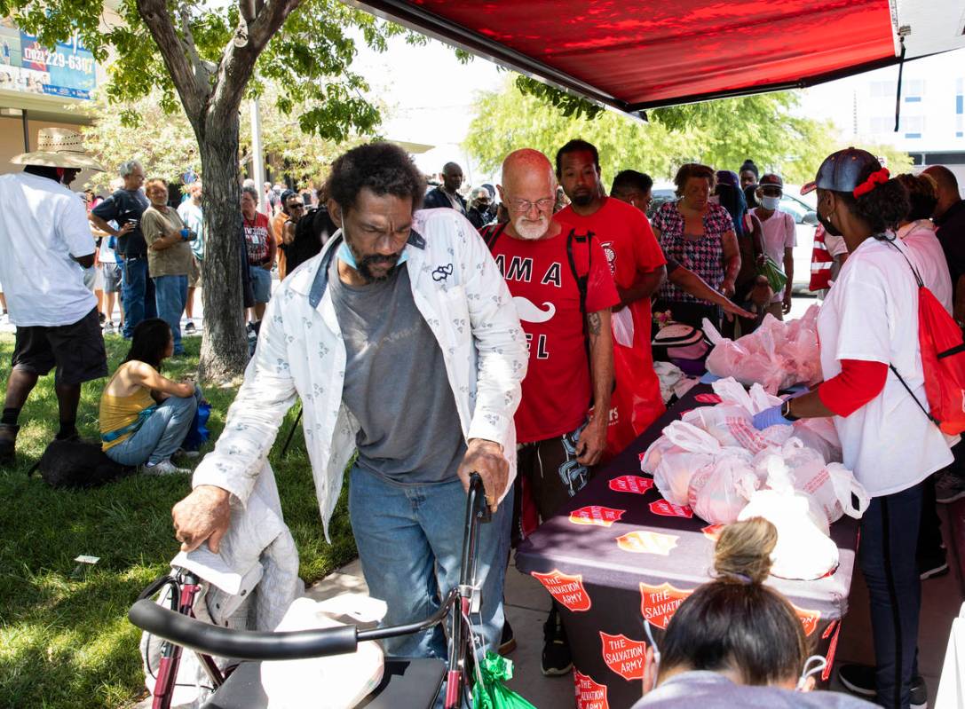Clients wait in a queue to receive free food from the Salvation Army food truck outside Dula Co ...