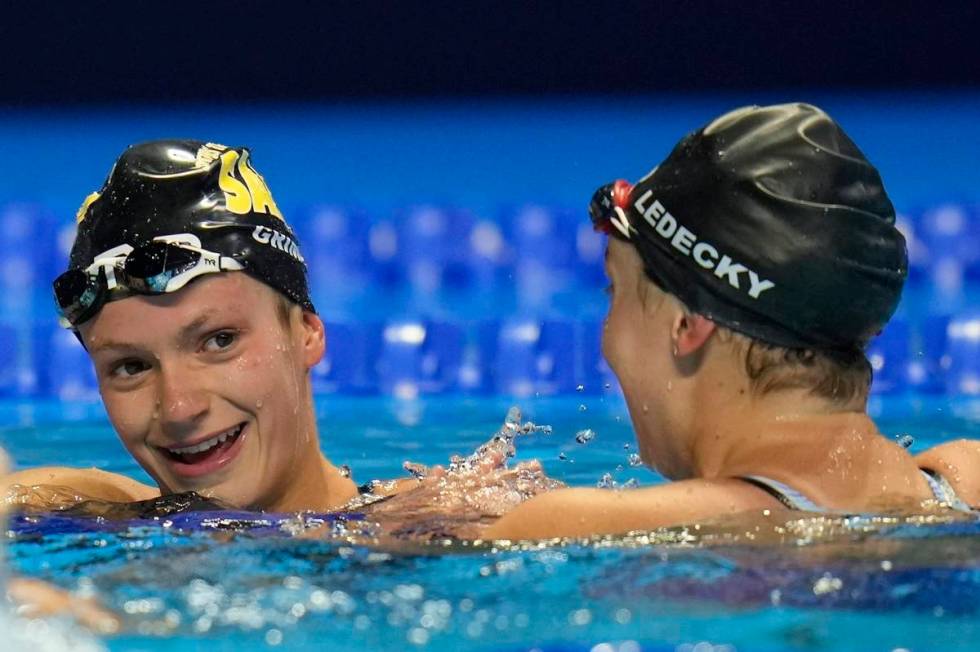 FILE - Katie Ledecky congratulates Katie Grimes after the women's 800 freestyle during wave 2 o ...