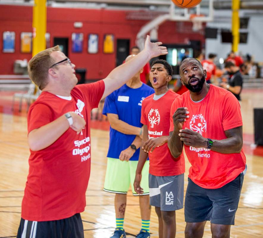 Denton Dorn, left, gets off a shot under the watchful eye of two-time NBA Slam Dunk Champion Ja ...