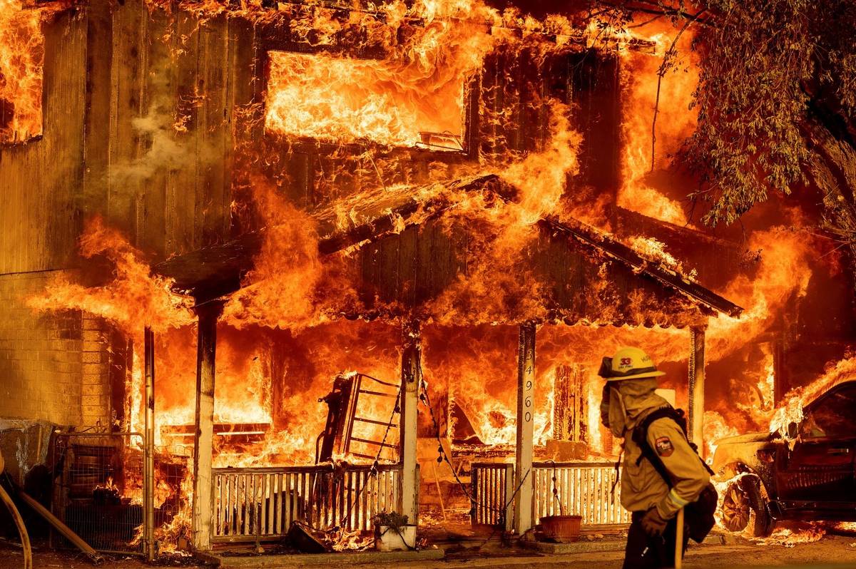 Fire consumes a home as the Sugar Fire, part of the Beckwourth Complex Fire, tears through Doyl ...