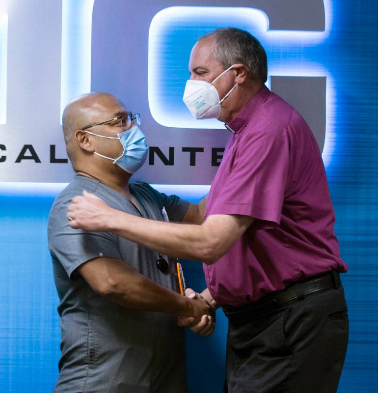 The Rev. Russ Smethers, right, a local pastor who was stabbed 21 times on March 8, shakes hands ...