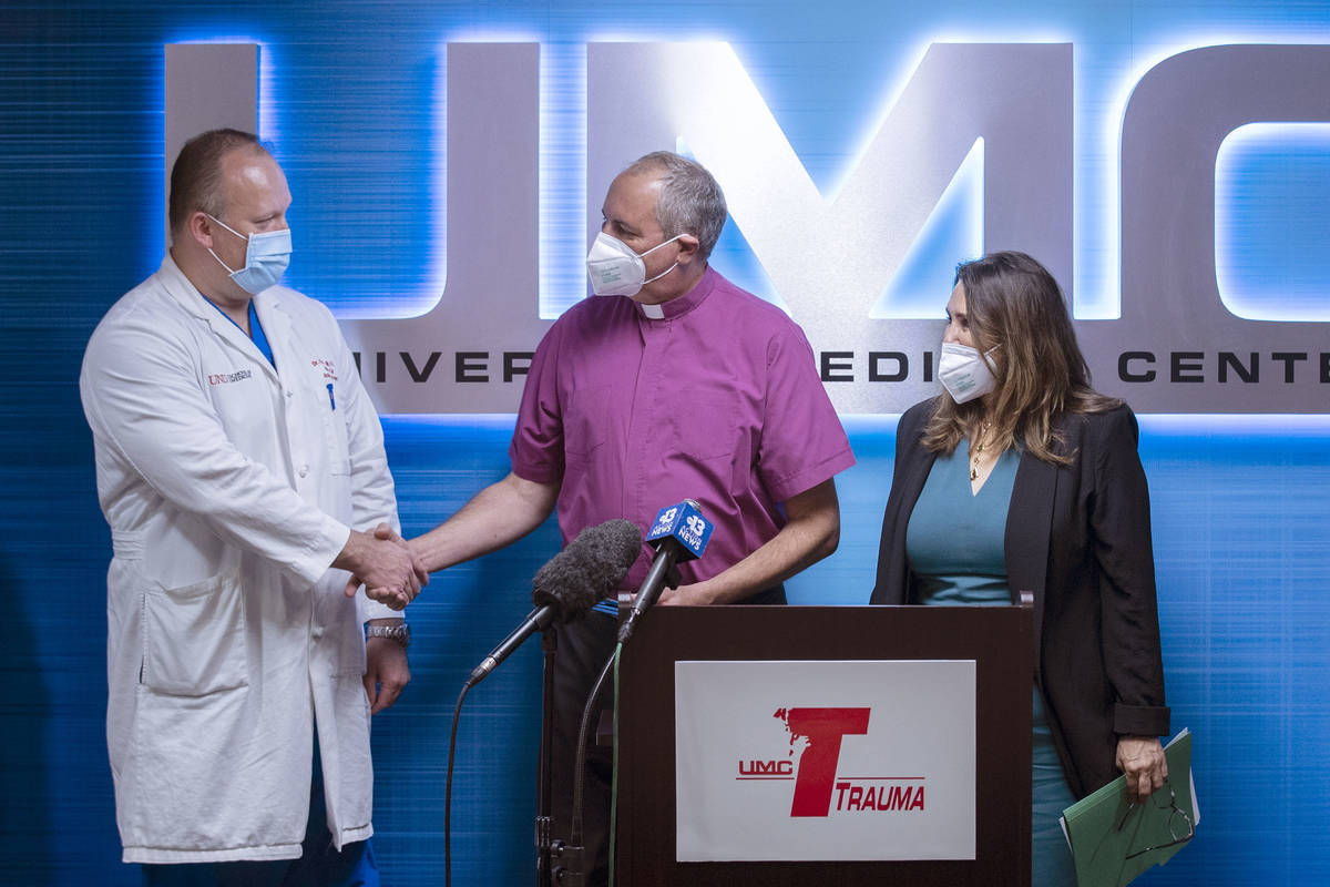 The Rev. Russ Smethers, center, a local pastor who was stabbed 21 times on March 8, shakes hand ...