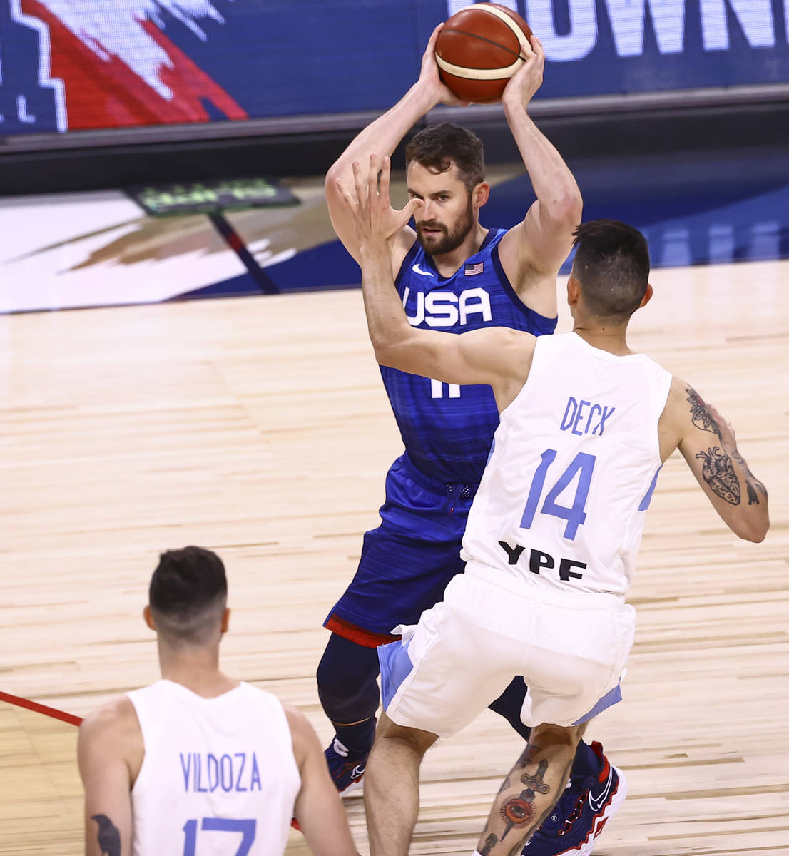 USAÕs Kevin Love (11) looks to pass the ball around ArgentinaÕs Gabriel Deck (14) dur ...