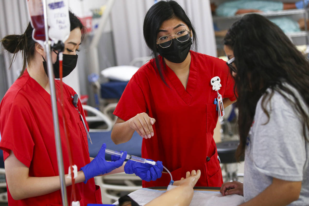 UNLV nursing students Susan Oh, left, and Kiara Andrada, center, show Camila Puente, a junior a ...