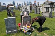 In this Sunday, May 10, 2020, file photo, Sharon Rivera adjusts flowers and other items left at ...