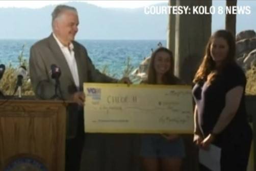 Gov. Steve Sisolak presents Chloe H. from Carson City a novelty check for $50,000 on Thursday, ...