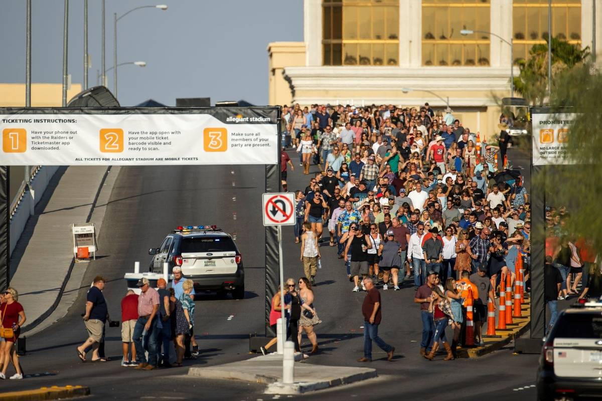 Fans make their way across the Hacienda overpass in the heat to the Garth Brooks concert at All ...