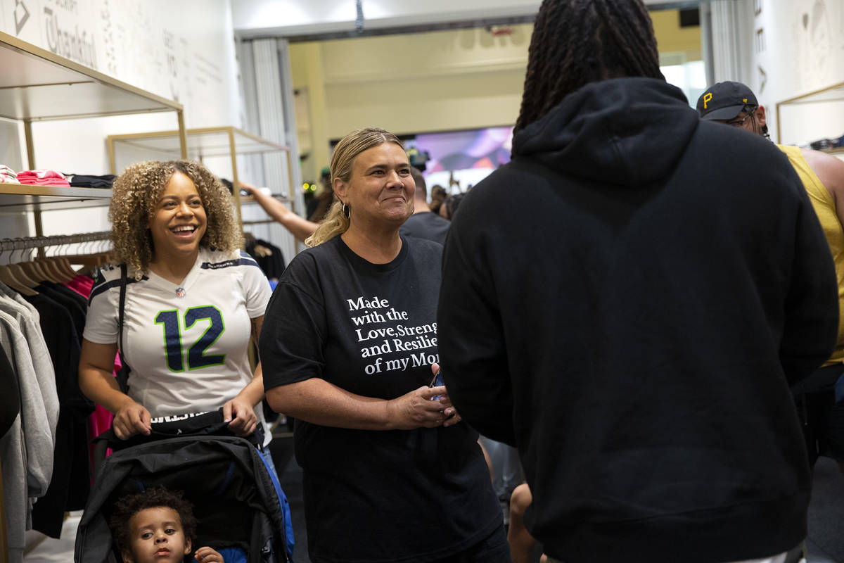 Jurnee Conway, left, and her mother Traci Conway, center, smile at NFL running back Marshawn Ly ...