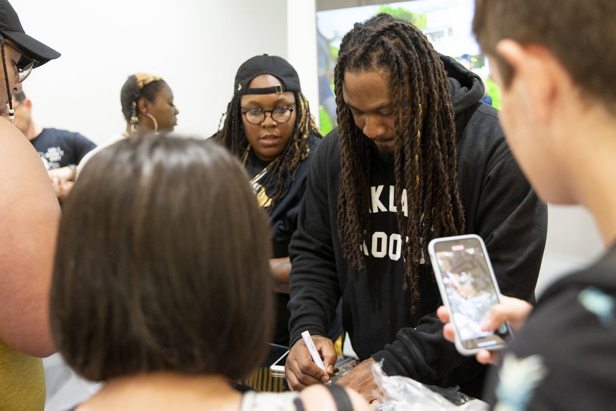 NFL running back Marshawn Lynch signs merchandise for fans and customers at the opening of his ...