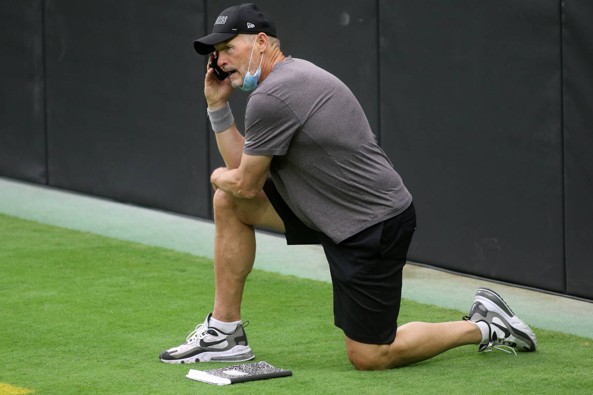 Las Vegas Raiders general manager Mike Mayock takes a phone call prior to a team practice at Al ...