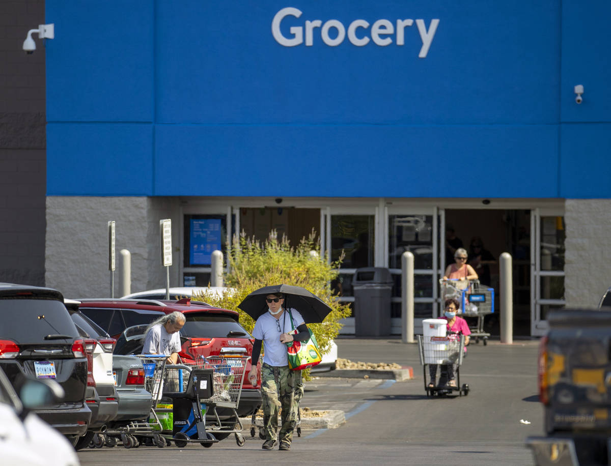 Shoppers make their way through a Walmart parking lot, most not wearing mask, on Friday, July 1 ...