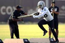 Raiders running back Josh Jacobs (28) runs with the football as running back coach Kirby Wilson ...