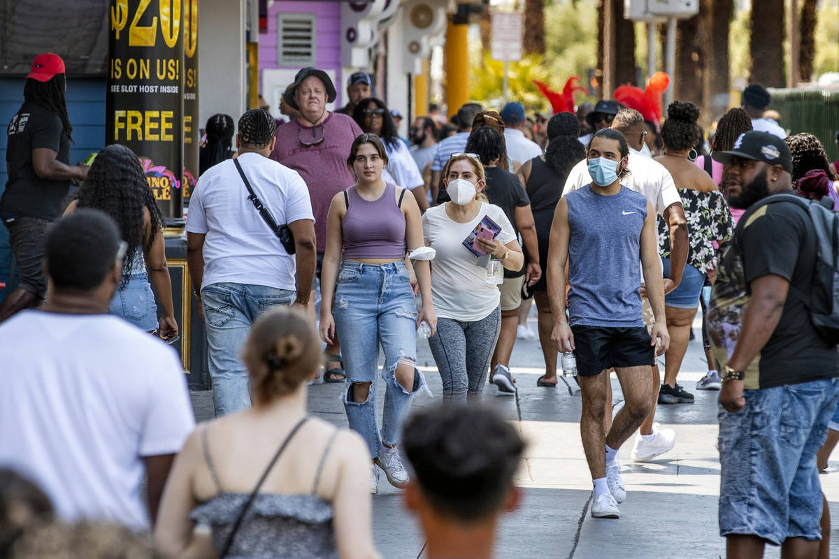 People walk along the Strip near The Venetian, most not wearing masks, on Friday, July 16, 2021 ...