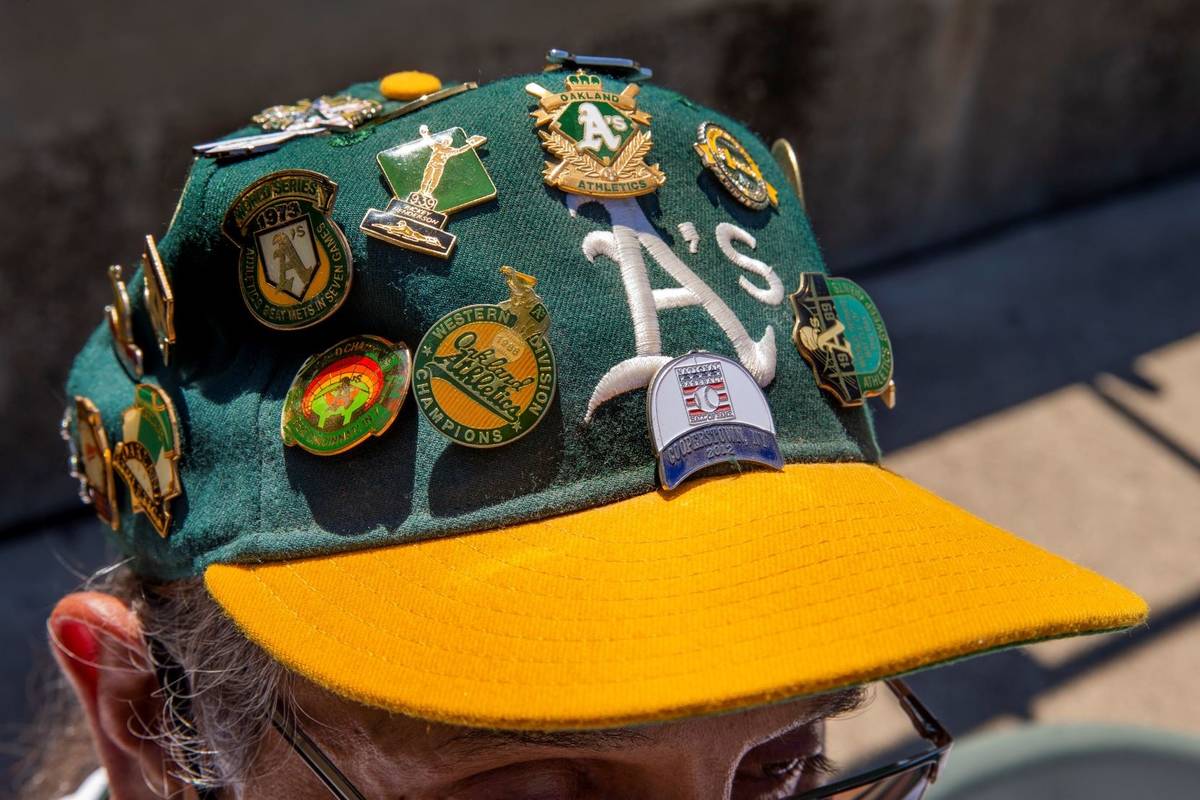 An Oakland A‘s fan sports a variety of pins on his hat as they battle the Texas Rangers at th ...