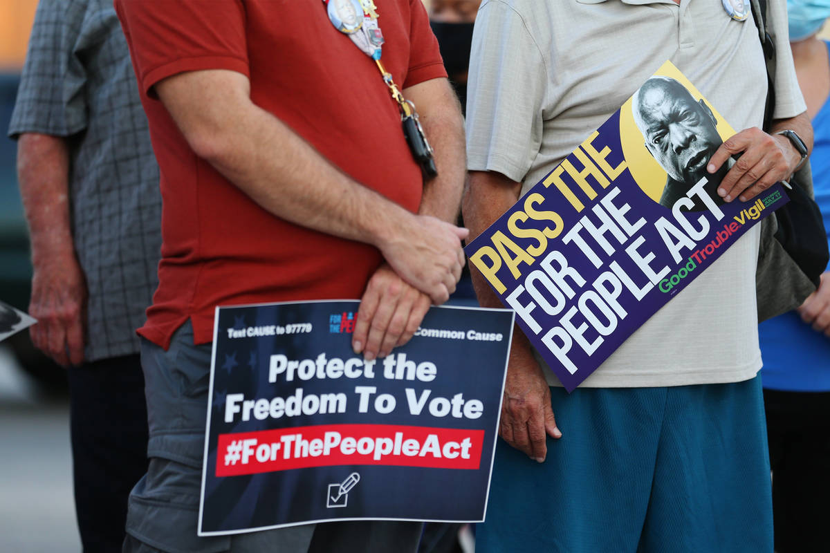 People attend a Good Trouble candlelight vigil on the anniversary of the death of civil rights ...