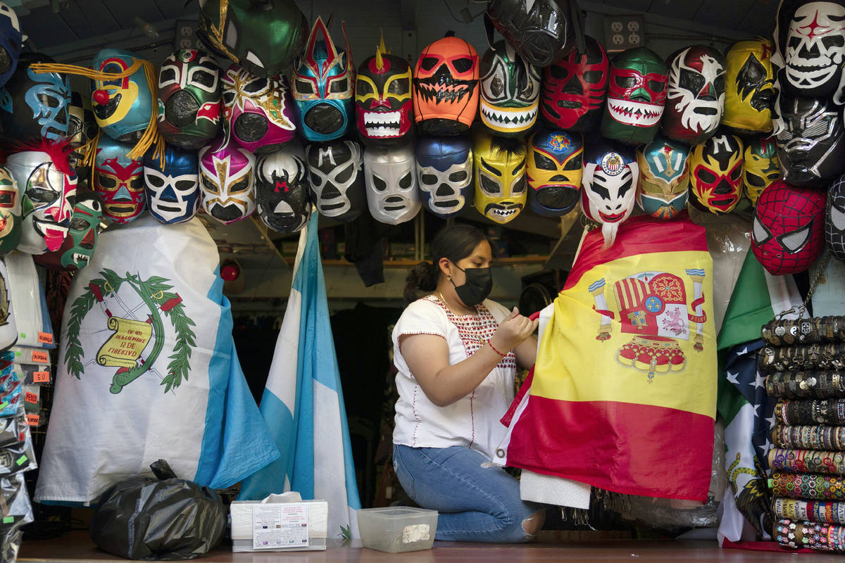 FILE - In this June 8, 2021, file photo, clerk Wendy Ramirez uses a Spanish flag to wrap souven ...