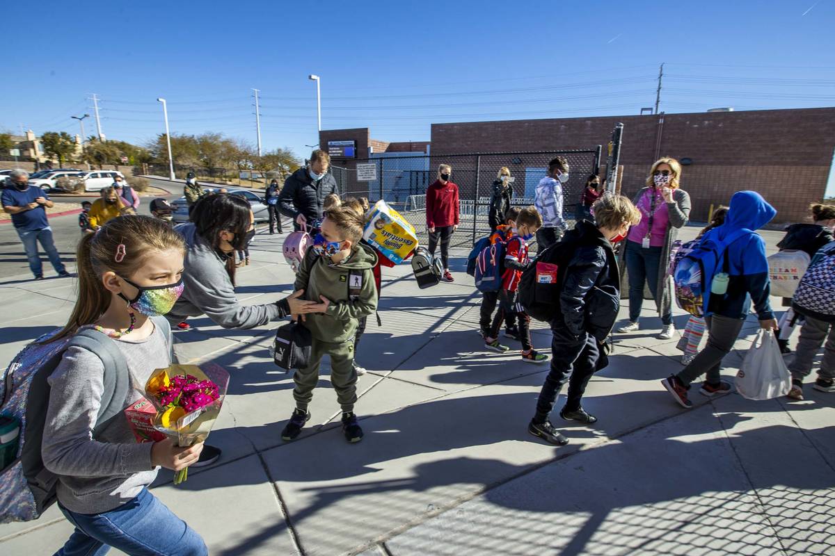 Students begin to enter a side gate at Goolsby Elementary School as they return to class on Mon ...