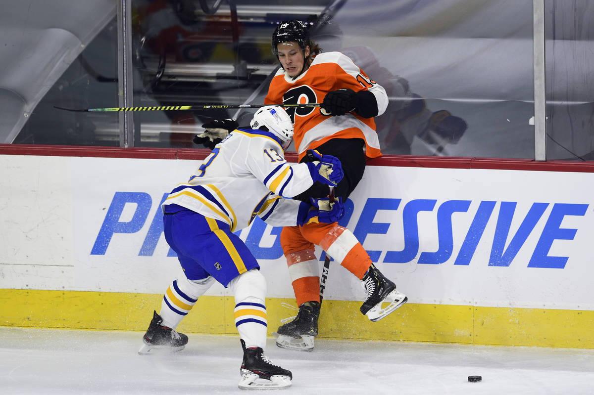 Philadelphia Flyers' Nolan Patrick, right, is checked into the boards by Buffalo Sabres' Tobias ...
