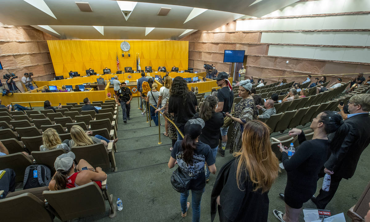 People line up to speak during the public comment portion of a meeting to discuss the increasin ...
