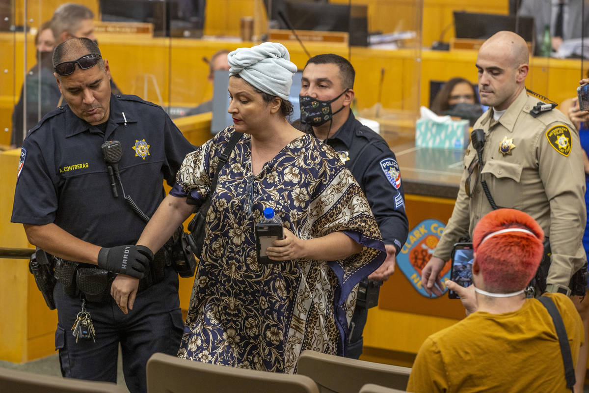 Officers escort Katrin Ivanoff from the Clark County Commission meeting for public outbursts as ...
