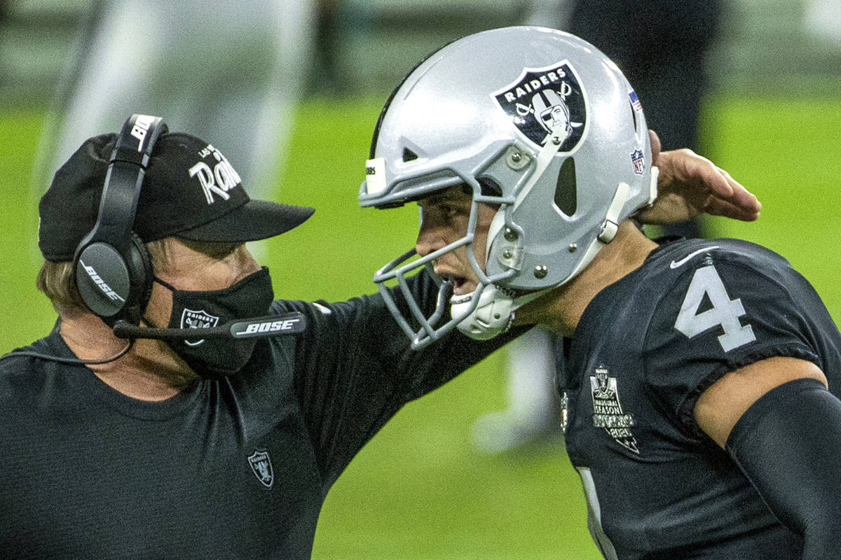 Raiders head coach Jon Gruden comes together on the sidelines with Raiders quarterback Derek Ca ...
