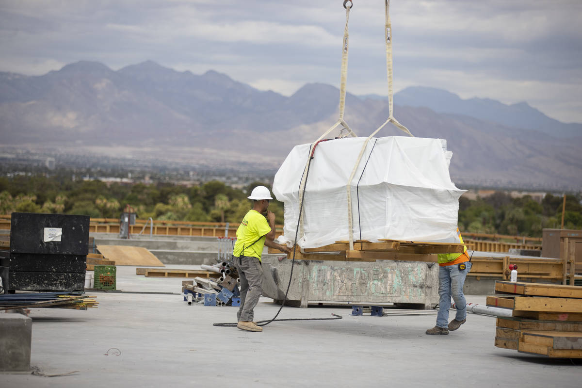 Workers move equipment on the building rooftop of the Kirk Kerkorian School of Medicine at UNLV ...