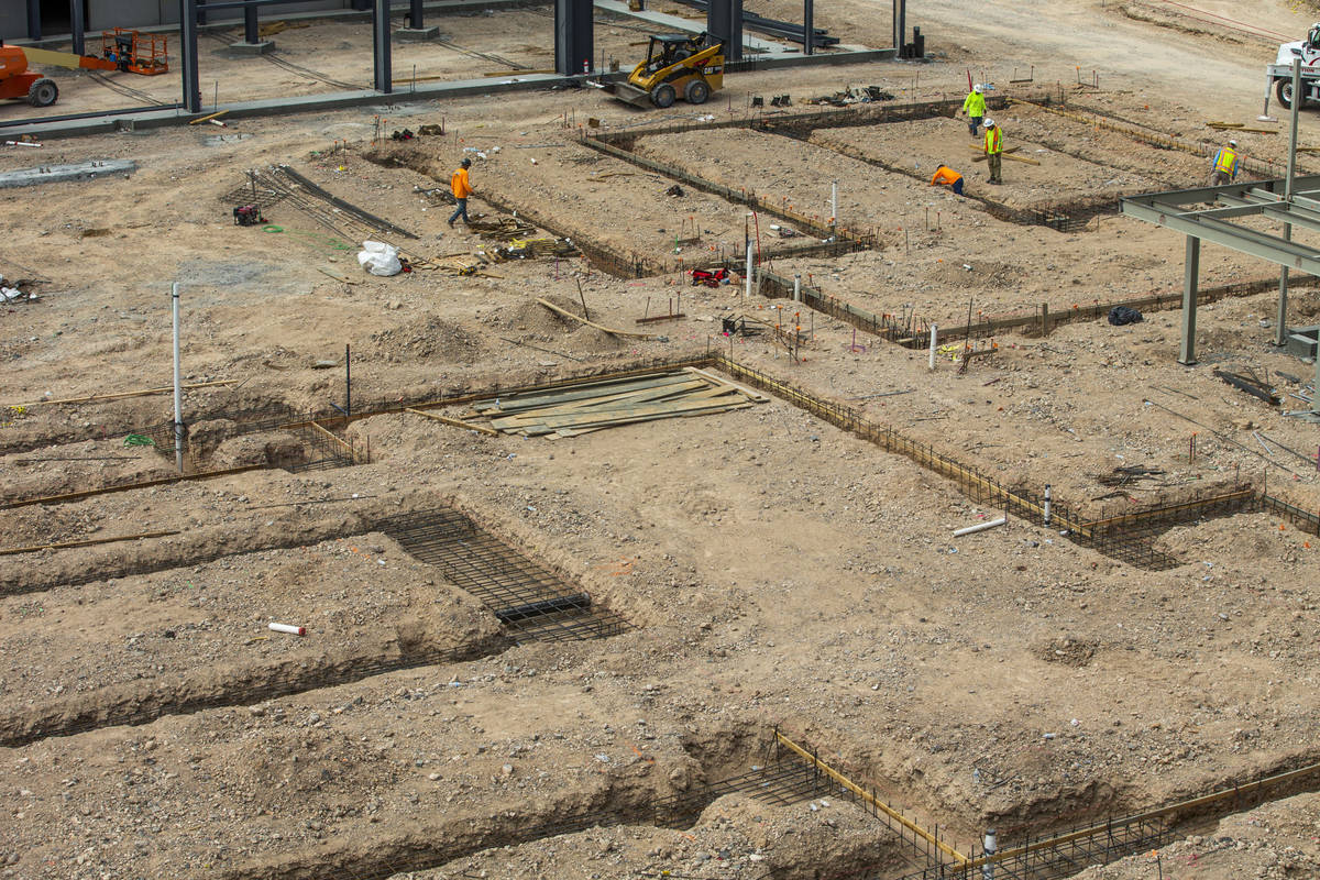 A crew works building foundations new the Market Hall at UnCommons, a mixed-use complex being b ...