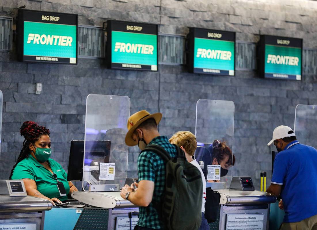 Guests check in at the Frontier counter in terminal three of McCarran International Airport in ...