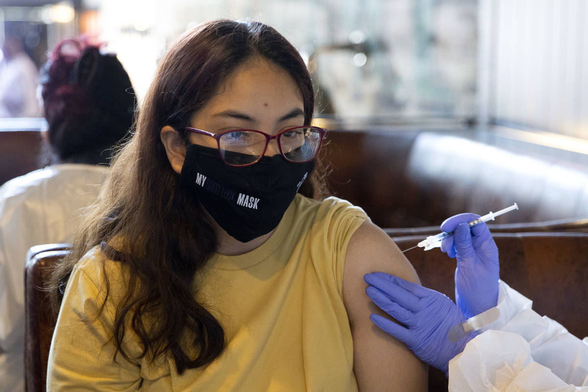 Stephanie Reyes, of Las Vegas, receives the Pfizer COVID-19 vaccination during a pop-up vaccina ...
