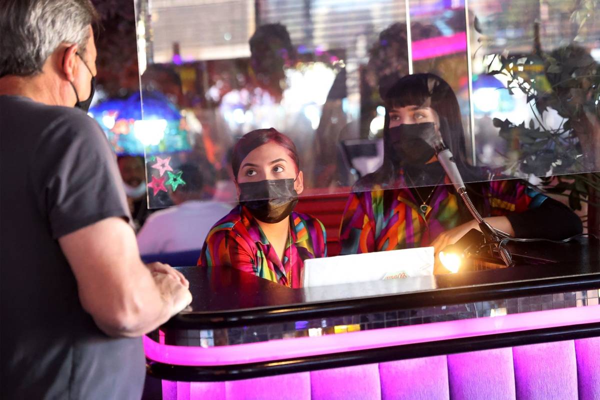 Hostesses Cristina Montiel, left, and Esmeralda Valencia, assist a customer at the Peppermill r ...