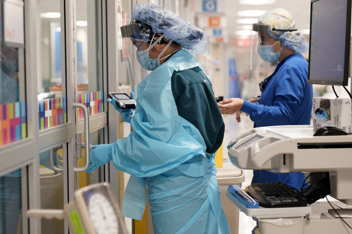 In this Oct. 28, 2020, file photo, medical personnel don PPE while attending to a patient (not ...