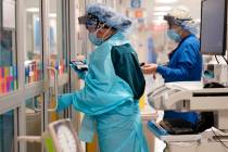 In this Oct. 28, 2020, file photo, medical personnel don PPE while attending to a patient (not ...
