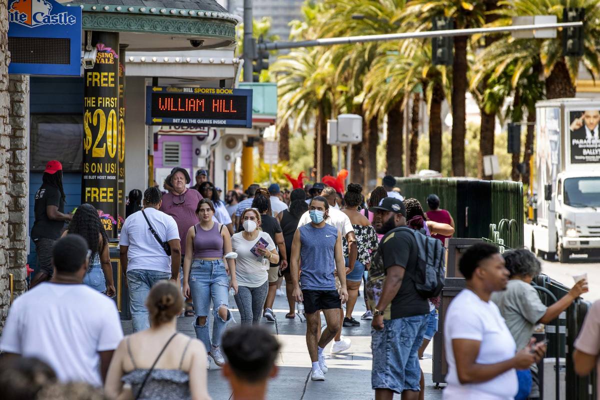 People walk along the Strip near The Venetian, most not wearing masks anymore on Friday, July 1 ...