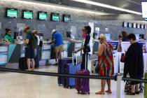 Guests check in at the Frontier counter in terminal three of McCarran International Airport in ...