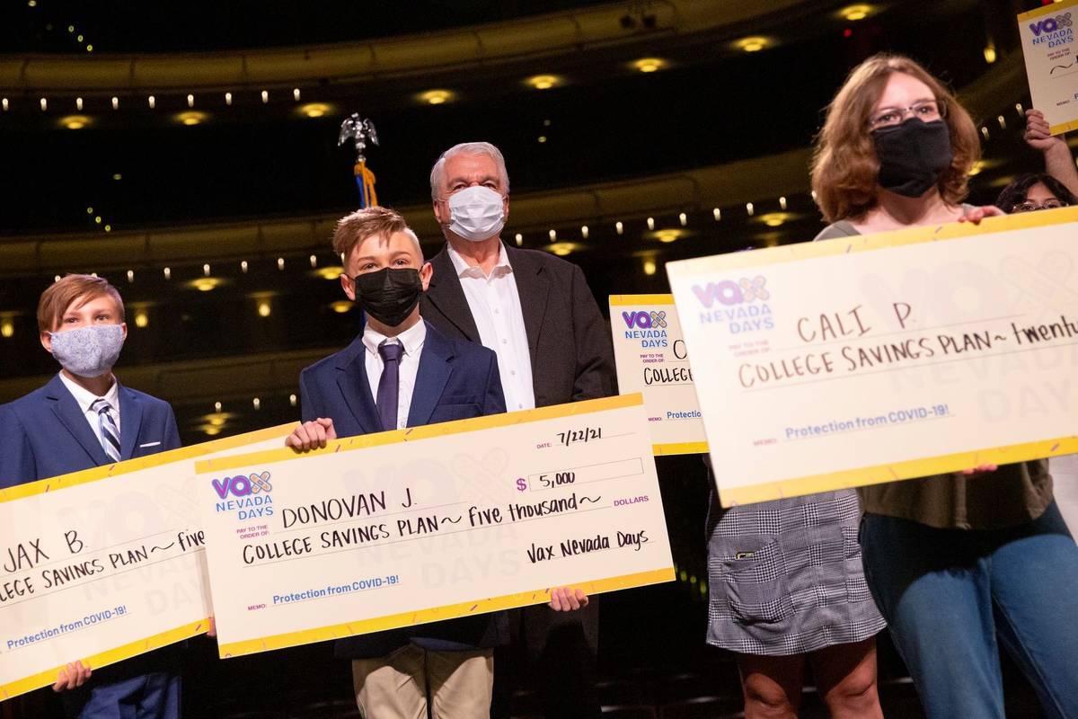 Gov. Steve Sisolak, center, poses for a photo with the third round Vax Nevada Days winners as t ...