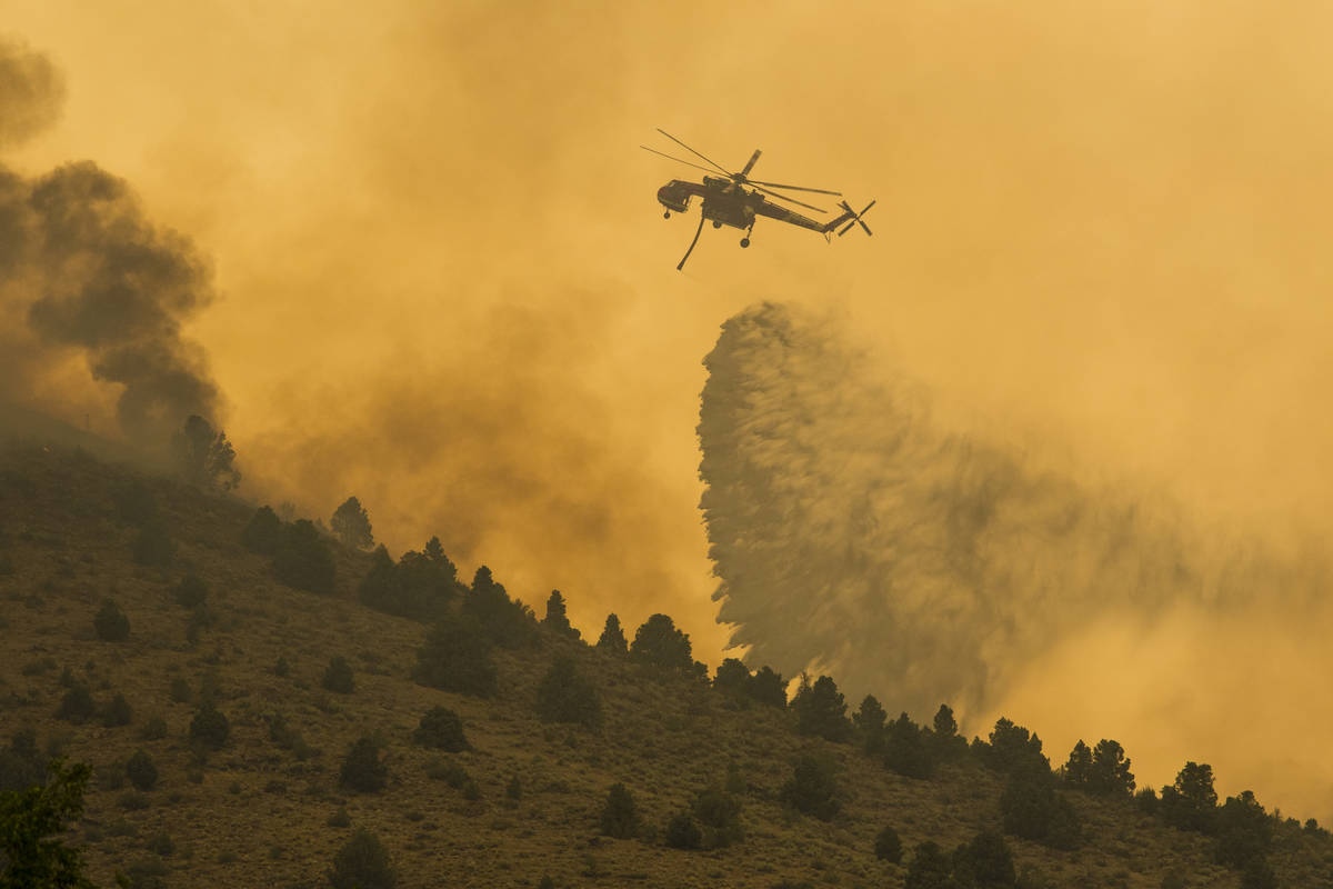 A firefighting chopper  drops h2o  arsenic  the Tamarack Fire burns astir   Topaz Lake, Nev., Frida ...